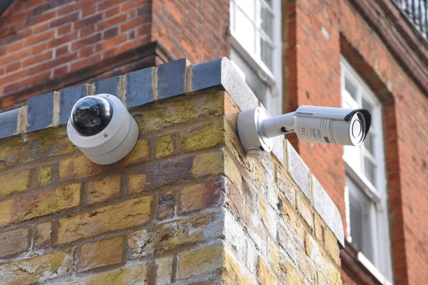 Two neatly installed security cameras on a brick wall in Melbourne