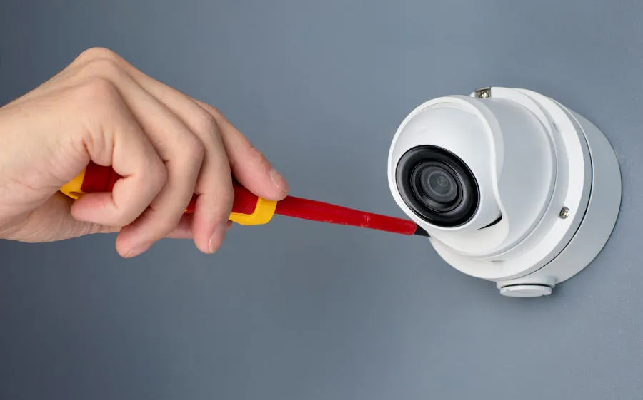 Close-up of a dome security camera being precisely adjusted during installation